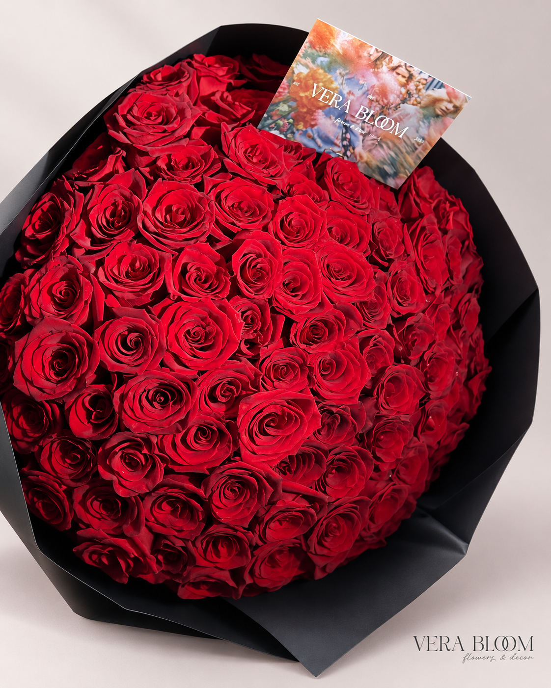 Close-up of red roses in black bouquet wrapping.