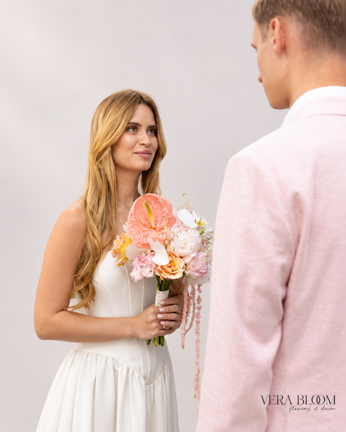 Bride holding a modern blush bouquet beside her partner.