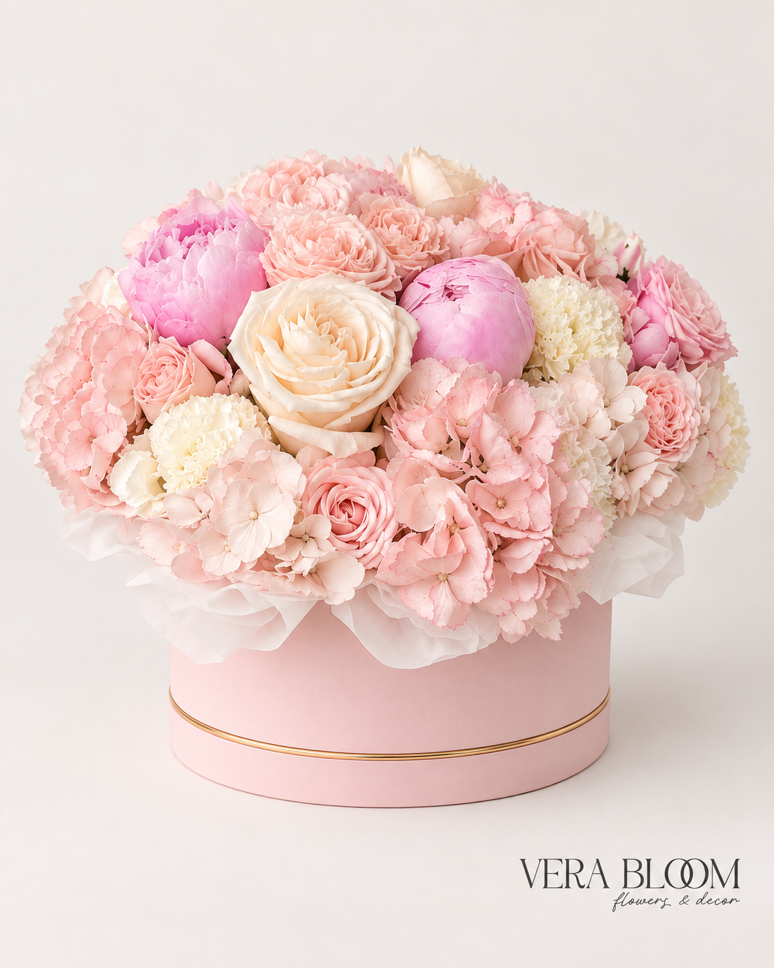 Front view of Rosé Garden Box with seasonal peonies, blush roses and ivory blooms in a pink box with gold trim.